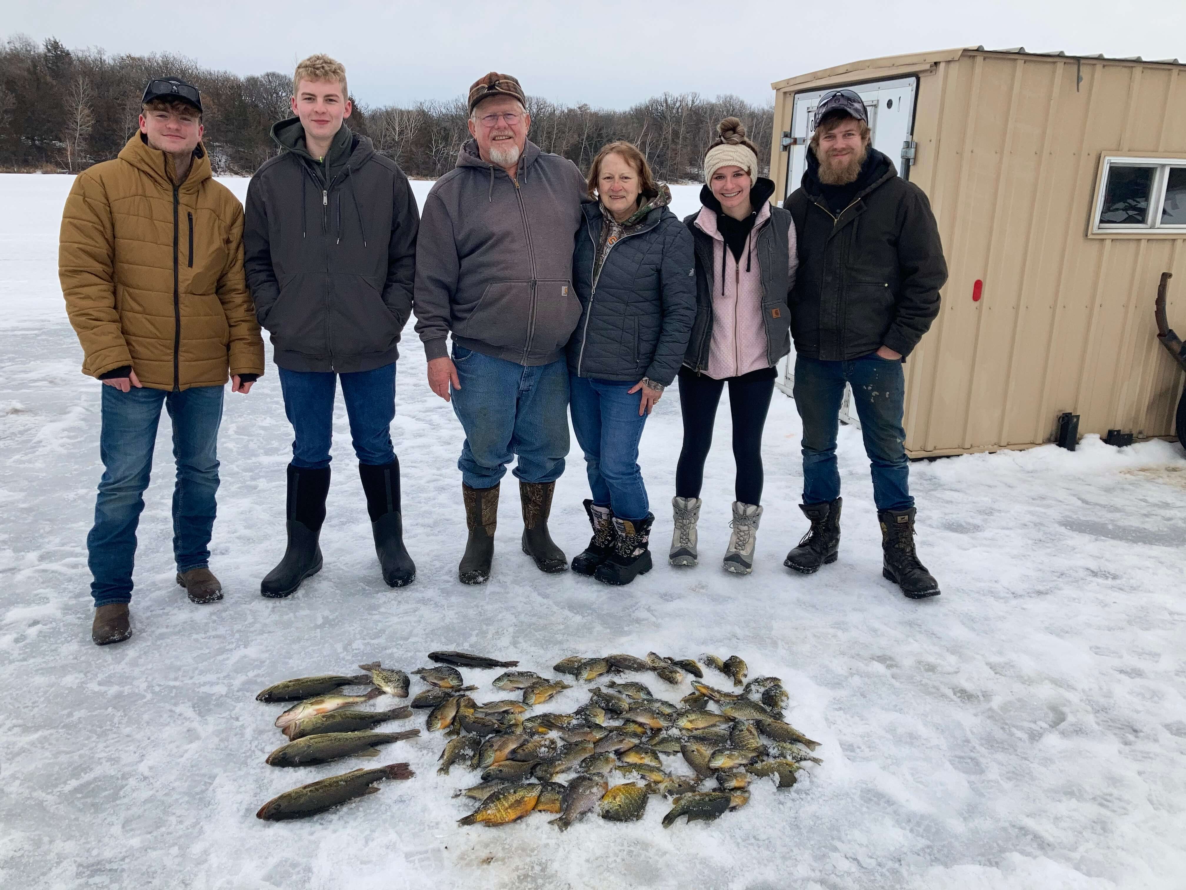 Family ice fishing trip with a pile of panfish