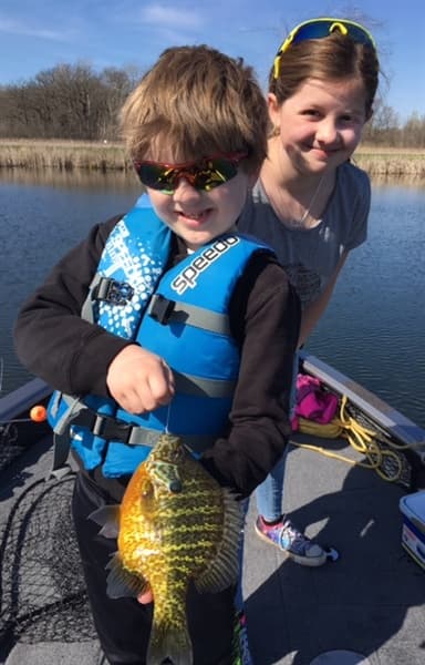Kids holding bluegill on a spring trip