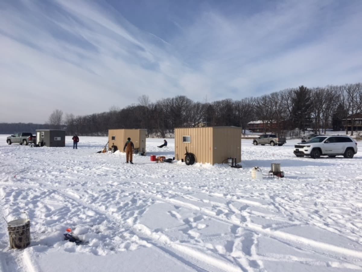 Group of ice fishing houses on a frozen lake