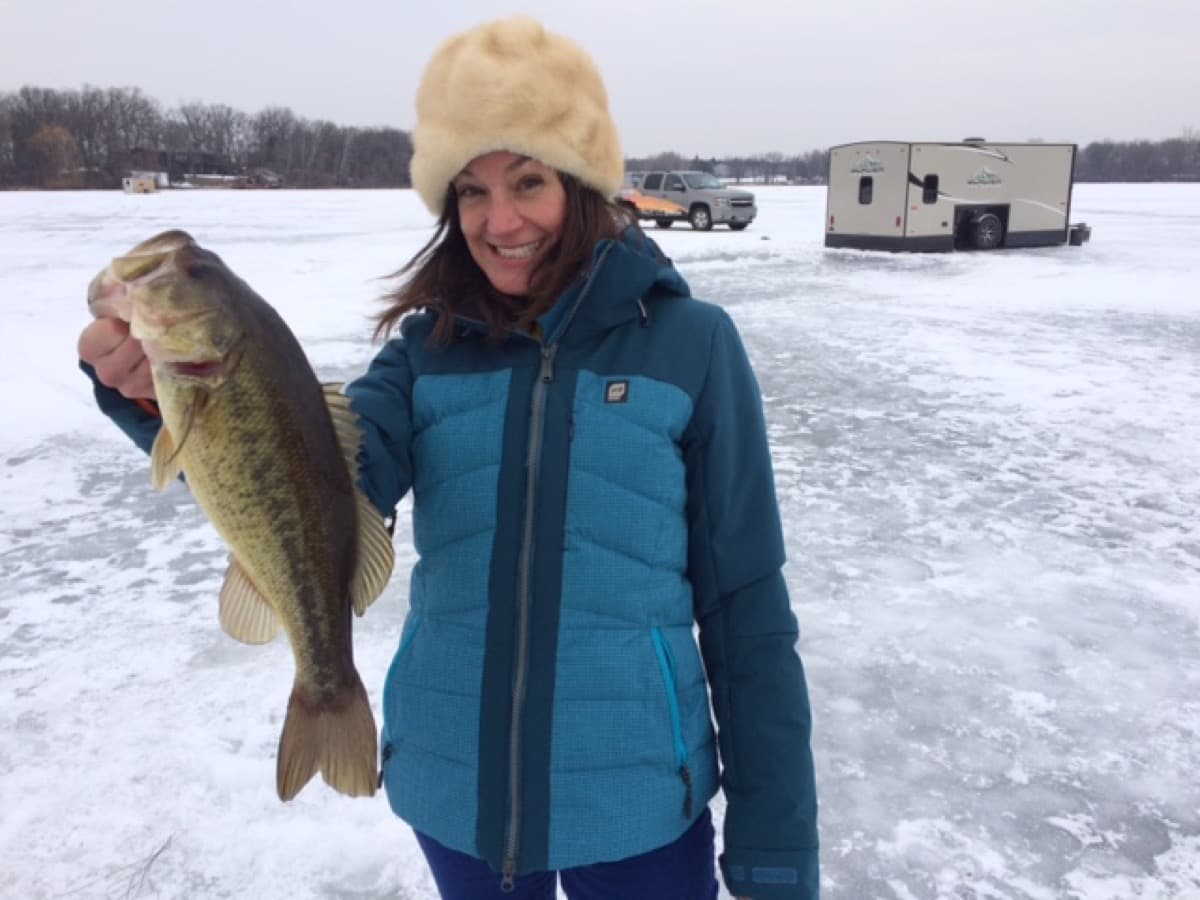 Girl with bass caught ice fishing in Canada