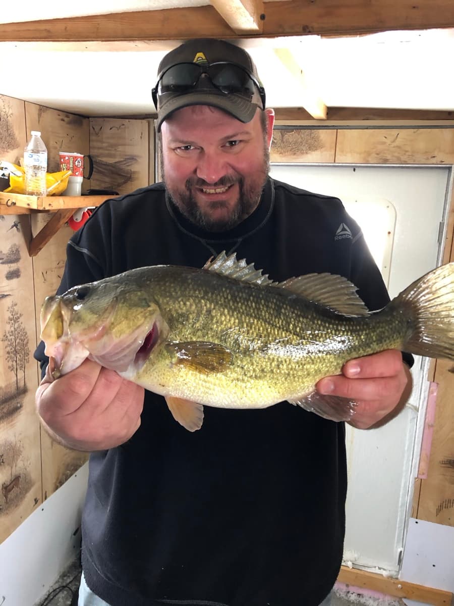 Angler with bass caught ice fishing
