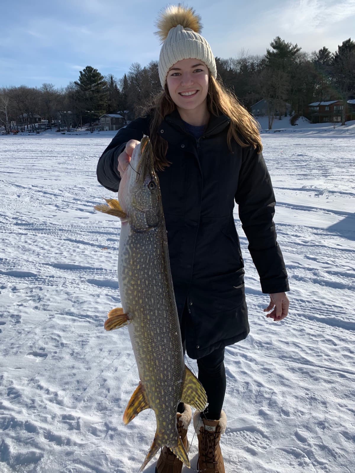 Girl holding a big pike caught ice fishing