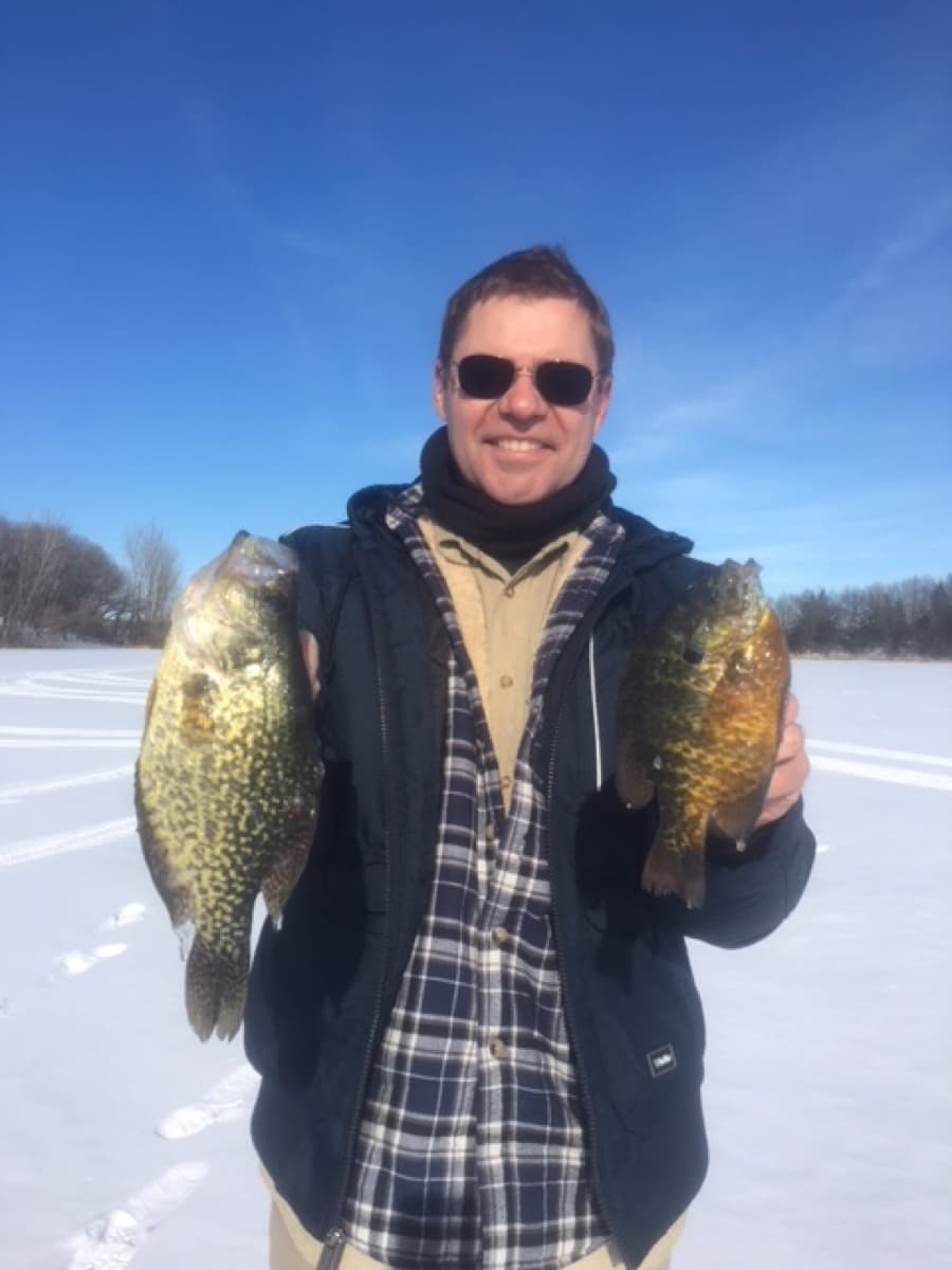 Angler with crappie and bluegill ice fishing