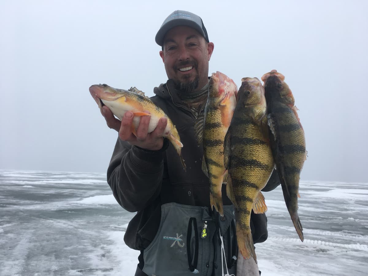 Scott holding a giant perch on the ice