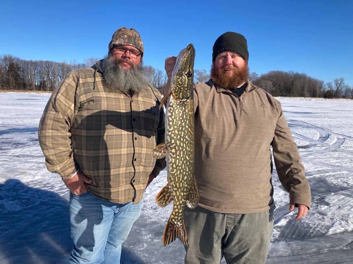 Two guys with pike outside the ice house