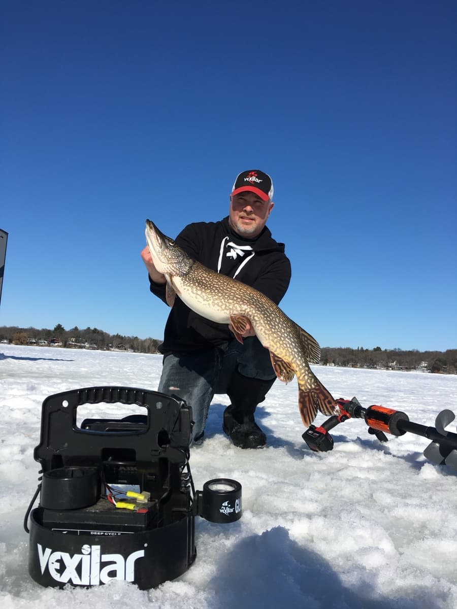 Captain Josh kneeling with a nice pike and Vexilar