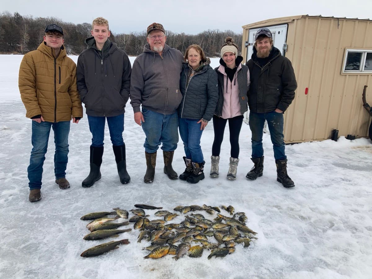 Family with pike and panfish on the ice