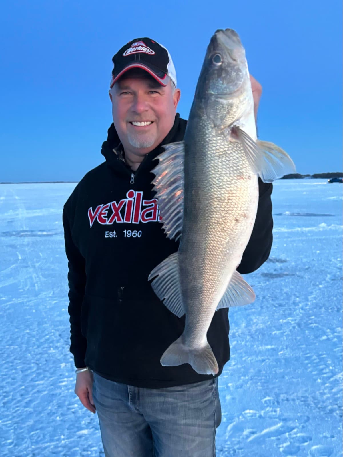 Captain Josh with a big walleye at sunset on the ice