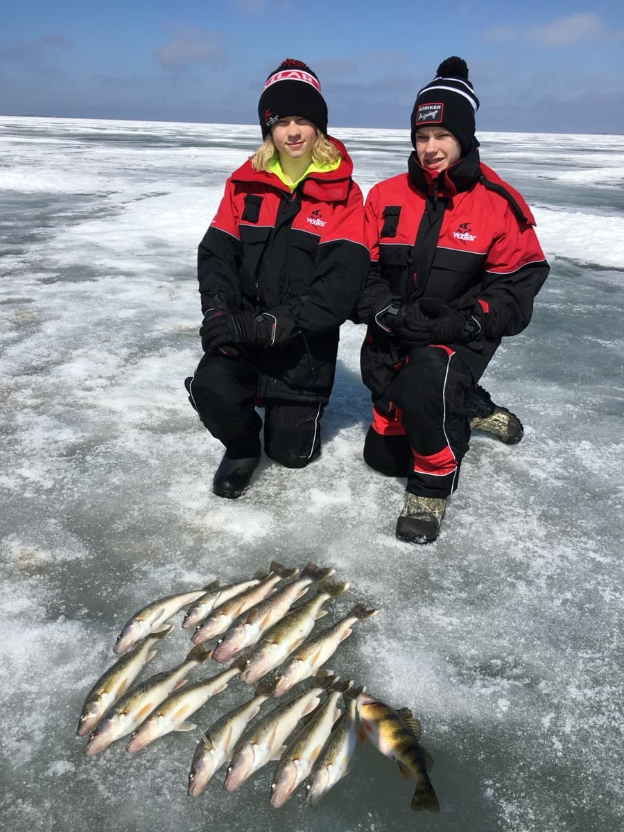 Two boys with ice fishing walleyes