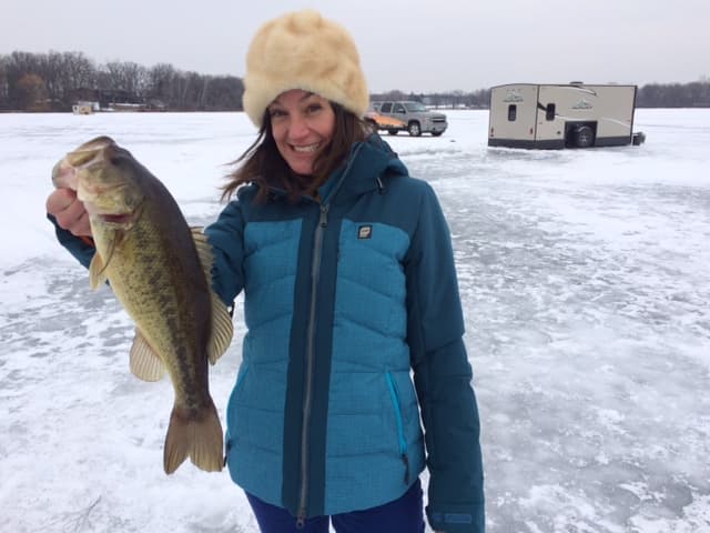 Girl with bass caught ice fishing