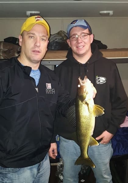 Guys with walleye in ice house